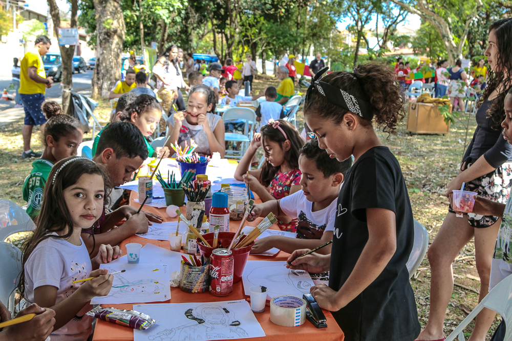 crianças estão sentadas a mesa pintando