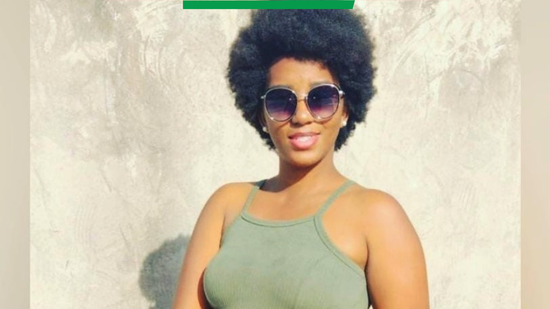 Foto de Laleska Caroline usando óculos escuros, blusa verde e sorrindo para a câmera
