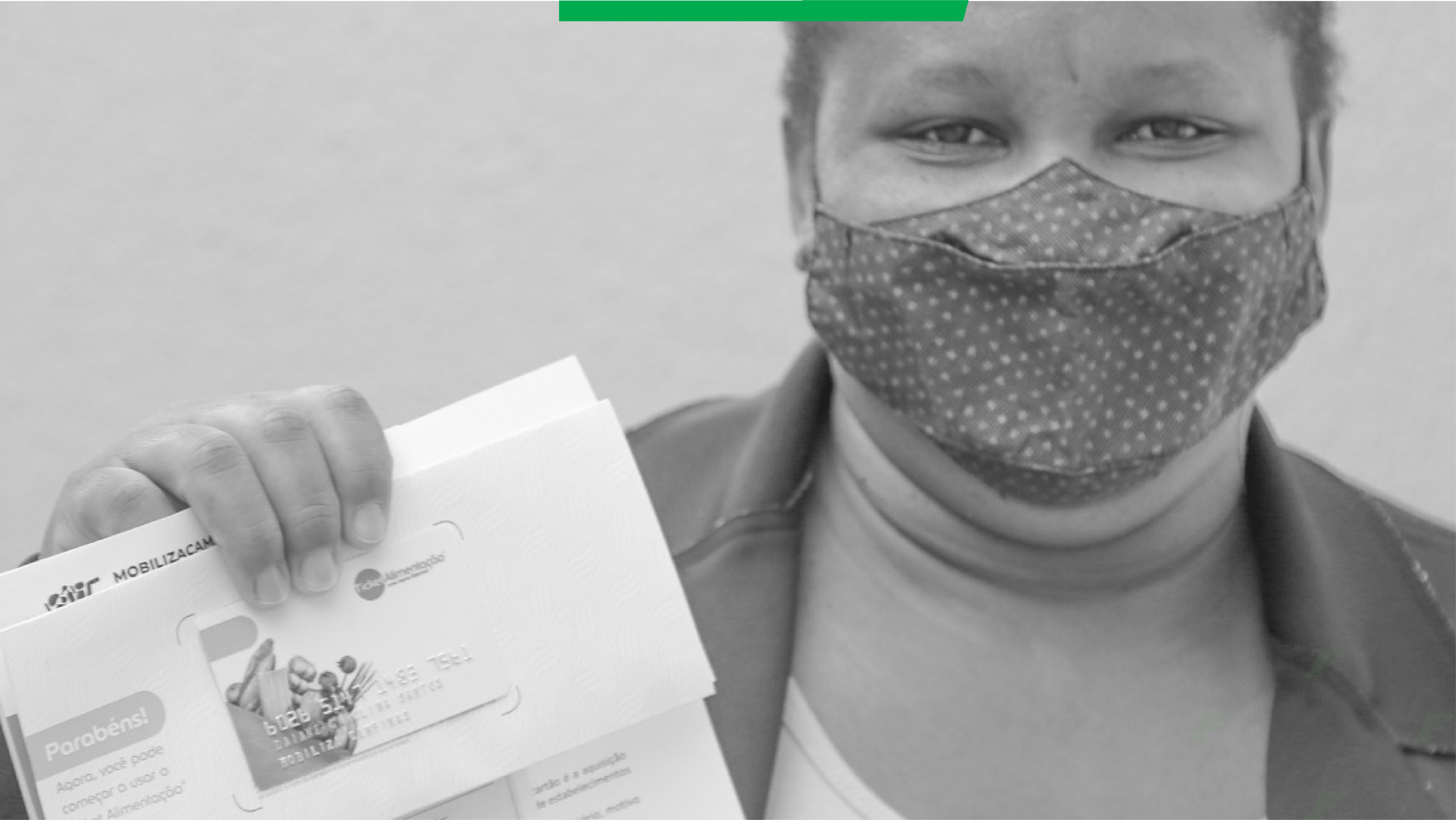 Imagem em preto-e-branco de mulher usando máscara e mostrando um cartão alimentação recebido da campanha Mobiliza Campinas